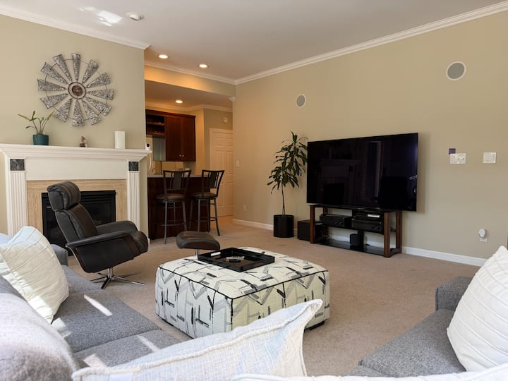 Living area with sectional sofa, television, fireplace, and kitchenette counter in the garden suite