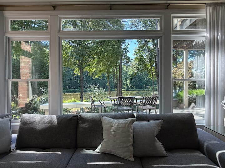 Lake and patio seen through the suite's wide garden-facing windows in North Raleigh