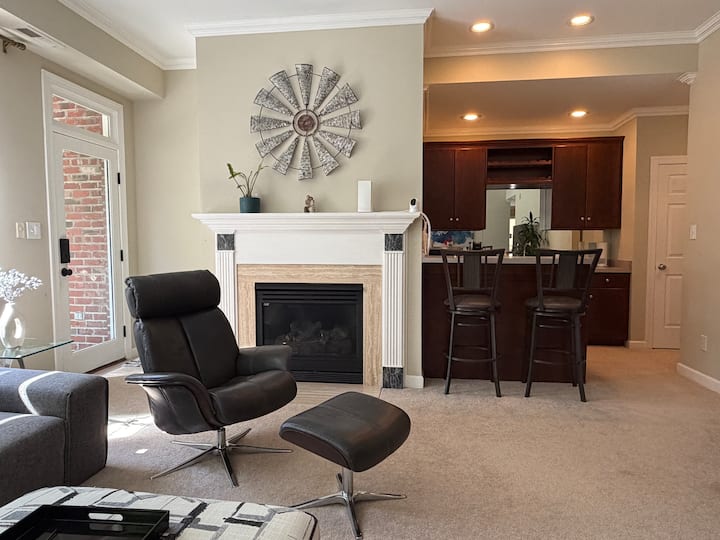 Fireplace, lounge chair, and kitchenette breakfast bar with two stools at the lakefront suite