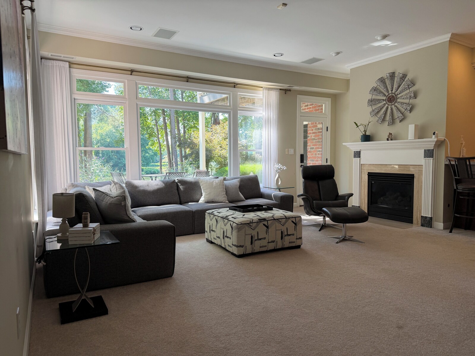 Sitting area with a sofa, ottoman, and fireplace in the garden-level suite